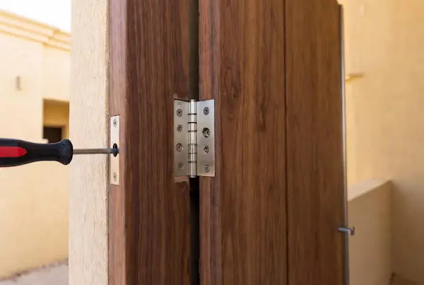 Wooden Door & Window Repair - Raseen UAE Carpenter repairing wooden door hinges in a villa in Dubai